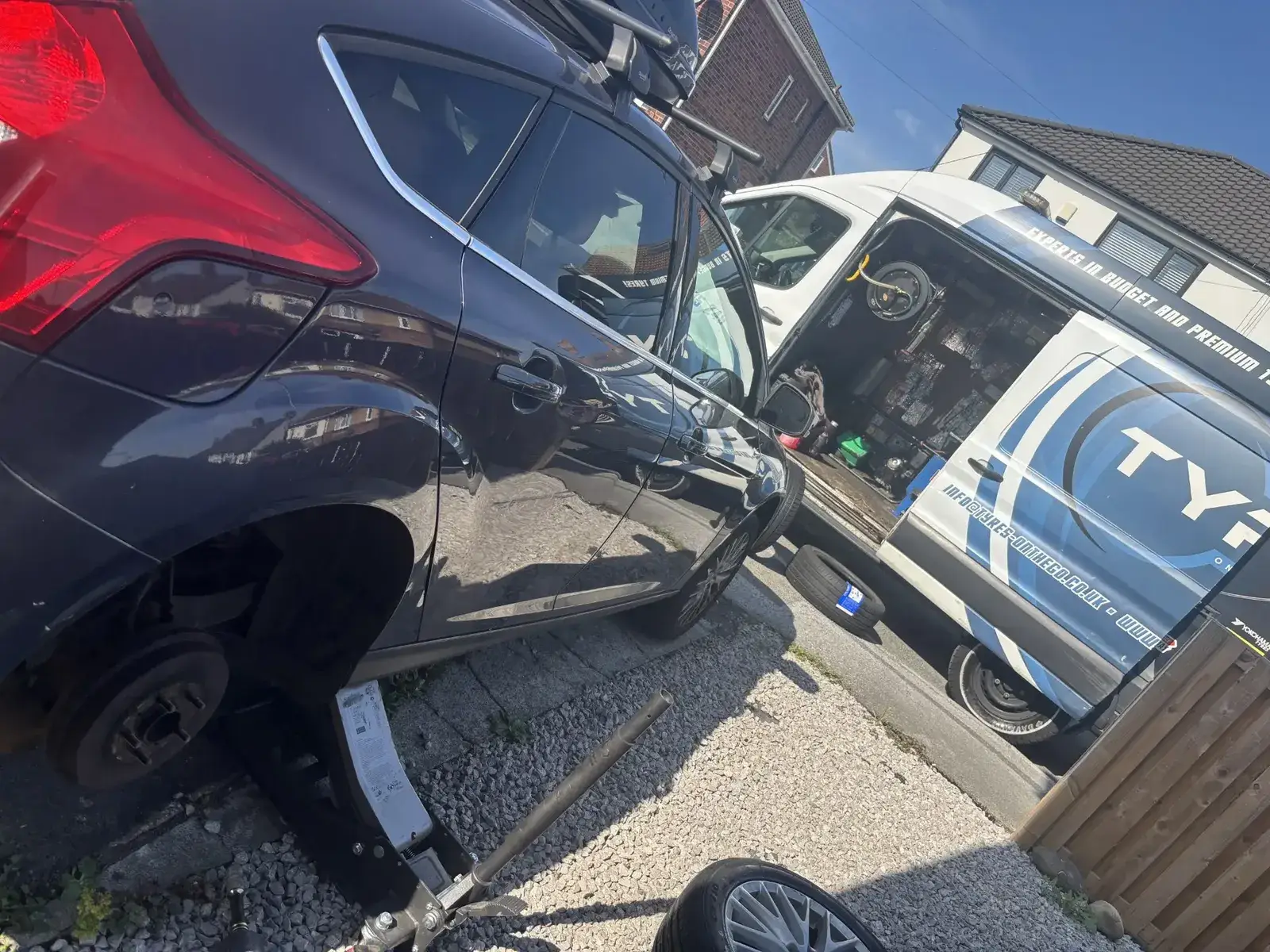 Mobile tyre fitter changing a car tyre at a customer's home in West Yorkshire